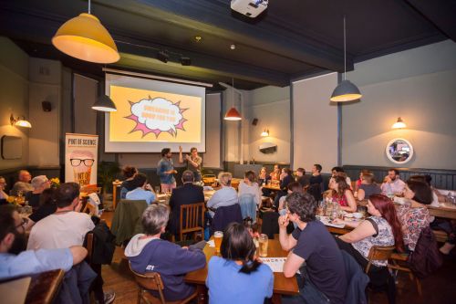 Science lecturers give talk to audience in pub setting